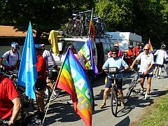 Foto: Alexander Gleich geht's weiter. Friedensradfahrer mit bunten Fahnen, im Hintergrund das Begleitfahrzeug mit Wohnanhäner. Foto: Alexander